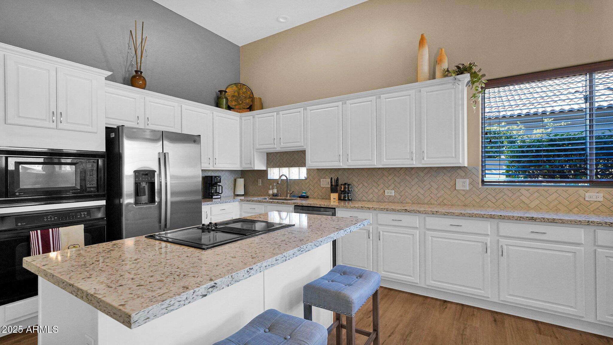 11516 East Ranch Gate Road Scottsdale, AZ 85255 - Photo 3 of 36 a kitchen with a refrigerator a stove a sink a counter space and cabinets