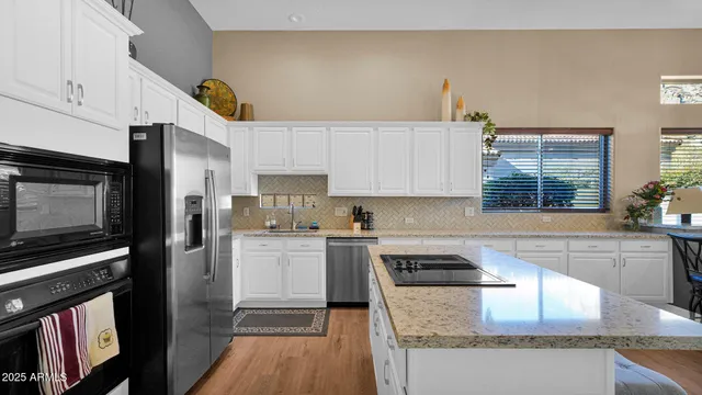 a kitchen with a sink a microwave a refrigerator and cabinets