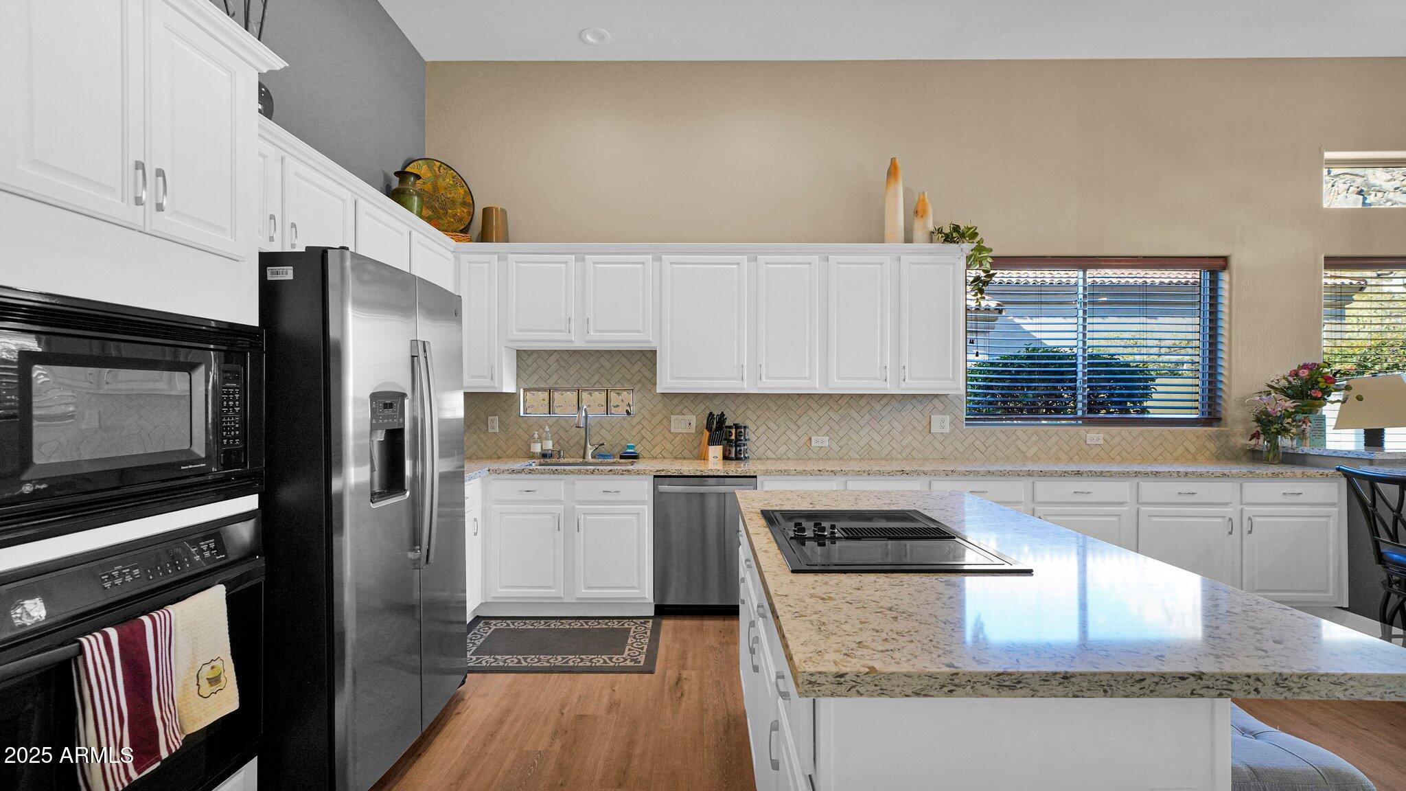 11516 East Ranch Gate Road Scottsdale, AZ 85255 - Photo 5 of 36 a kitchen with a sink a microwave a refrigerator and cabinets