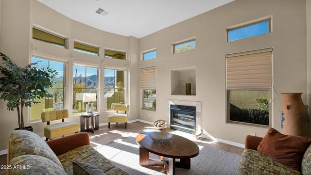 a living room with furniture fireplace and a large window