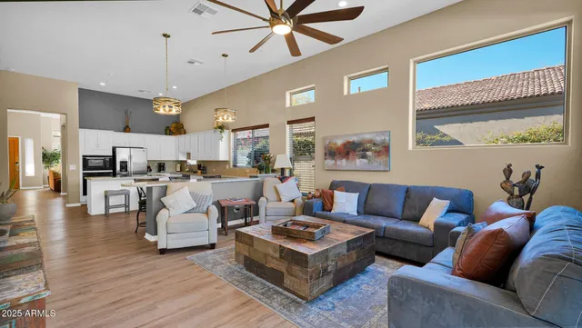 a living room with furniture kitchen view and a large window