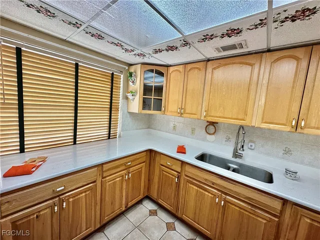 a kitchen with granite countertop a sink window and cabinets