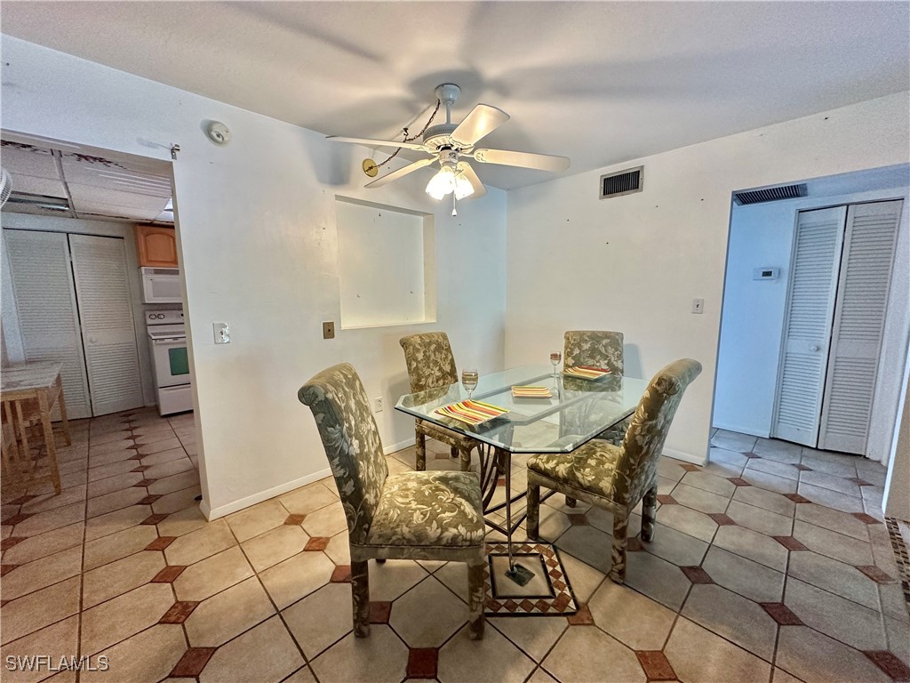 2828 Jackson Street, Unit F7 Fort Myers, FL 33901 - Photo 8 of 49 a view of a dining room with furniture and chandelier fan