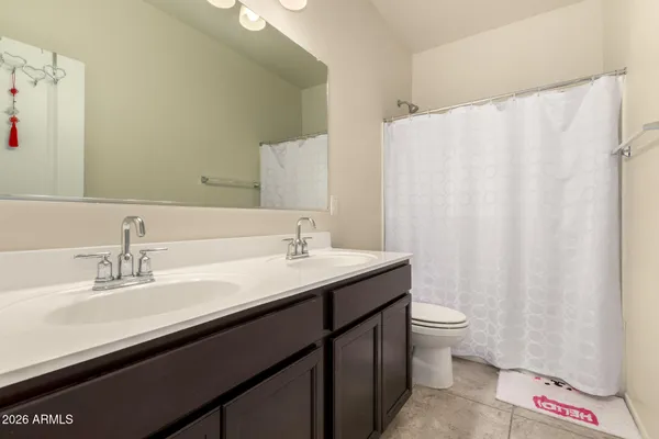 a bathroom with a double vanity sink toilet and a mirror