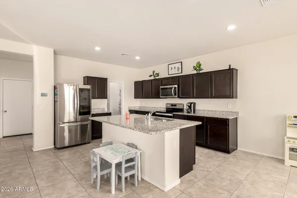a kitchen with stainless steel appliances granite countertop a refrigerator and a stove top oven
