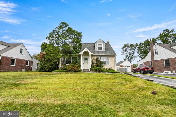 a front view of a house with a garden and tree