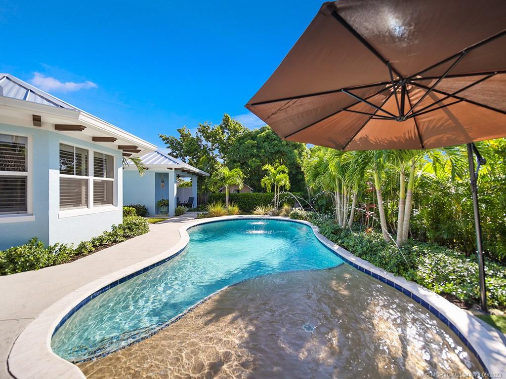 5714 Southeast Horseshoe Point Road Stuart, FL 34997 - Photo 51 of 83 a view of a patio with a table and chairs under an umbrella