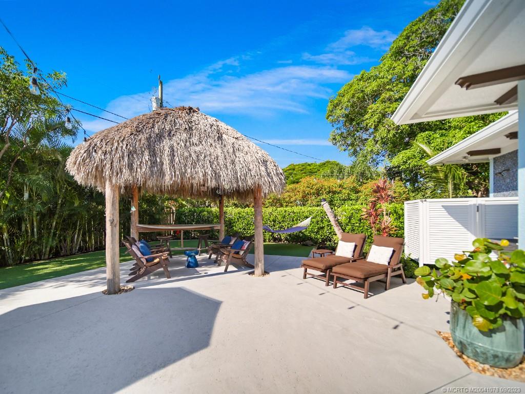 5714 Southeast Horseshoe Point Road Stuart, FL 34997 - Photo 57 of 83 a view of a patio with a table and chairs under an umbrella