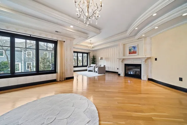 a view of an empty room with furniture a fireplace and windows