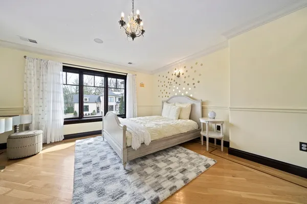 a bedroom with a large bed and a chandelier