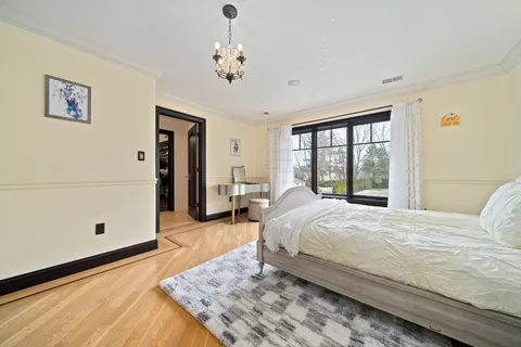 a spacious bedroom with a bed and a dresser next to a window
