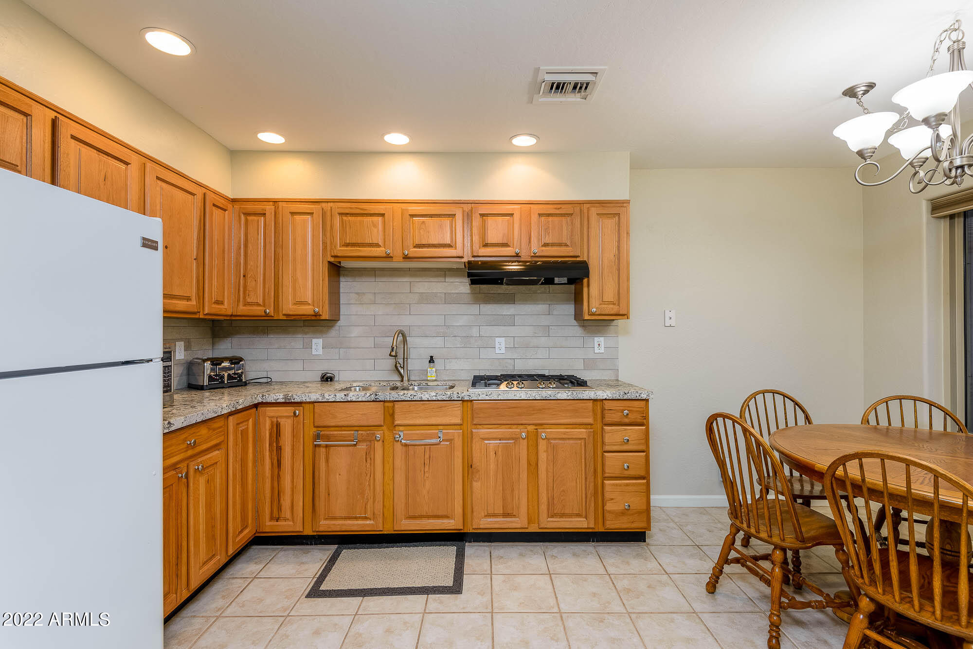 7754 East La Junta Road Scottsdale, AZ 85255 - Photo 43 of 72 a kitchen with a sink a refrigerator and chairs