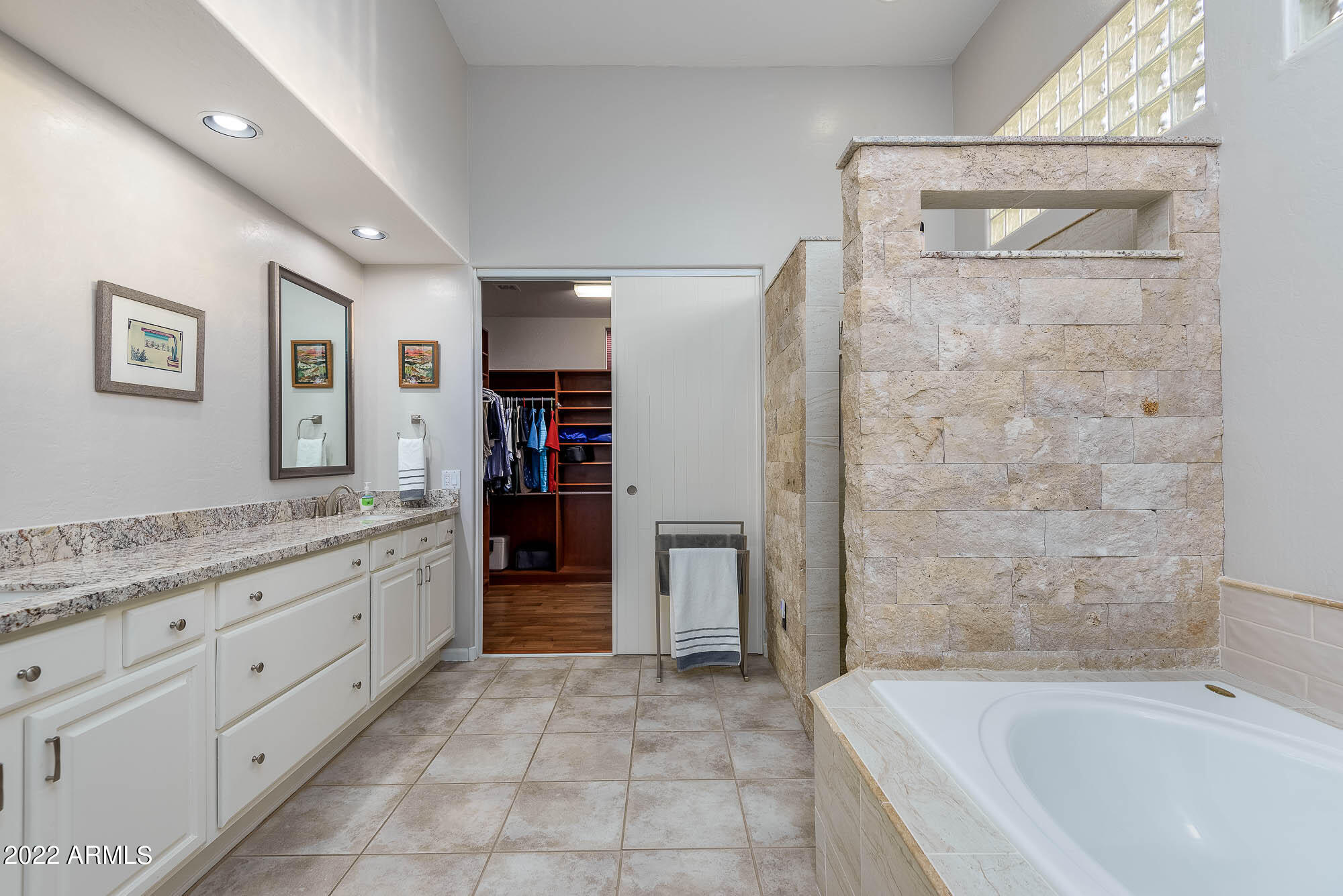 7754 East La Junta Road Scottsdale, AZ 85255 - Photo 9 of 72 a bathroom with a granite countertop sink a mirror a bathtub and shower