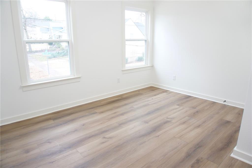 708 Rochelle Drive Southwest Atlanta, GA 30310 - Photo 14 of 24 an empty room with wooden floor and windows