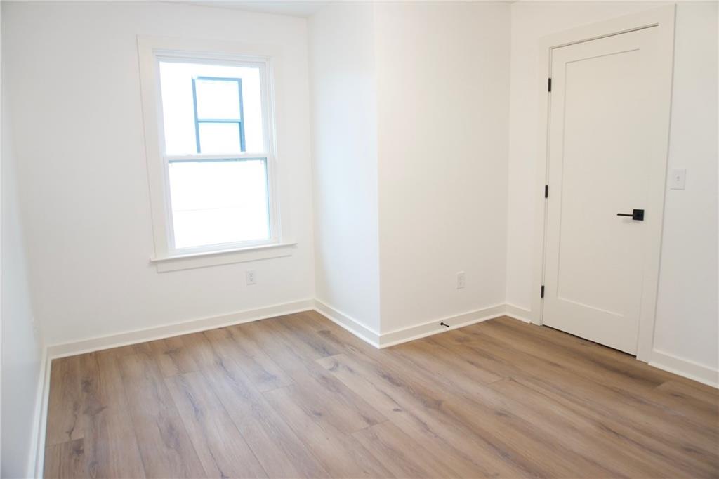 708 Rochelle Drive Southwest Atlanta, GA 30310 - Photo 17 of 24 an empty room with wooden floor and windows