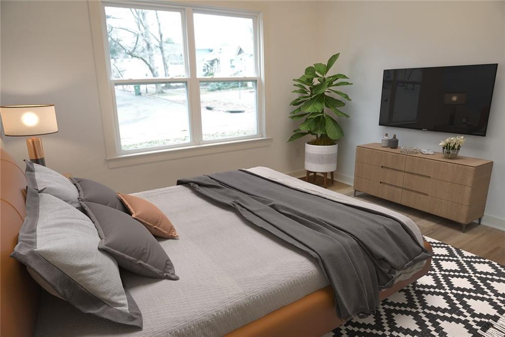 708 Rochelle Drive Southwest Atlanta, GA 30310 - Photo 21 of 24 a bedroom with a bed potted plant and a flat screen tv