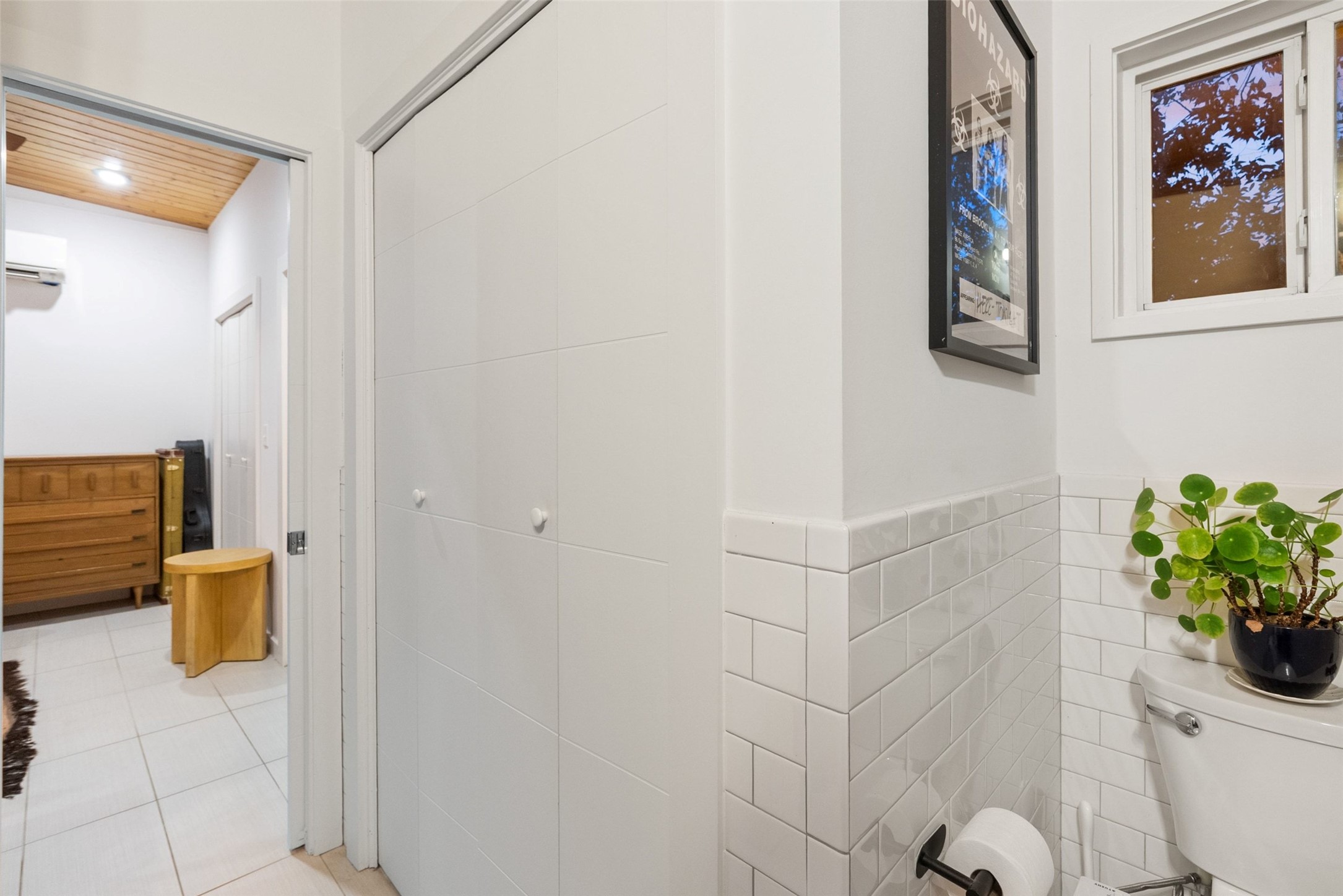 412 West Croslin Street Austin, TX 78752 - Photo 31 of 36 A corner of the bathroom features subway tile wainscoting and a toilet.