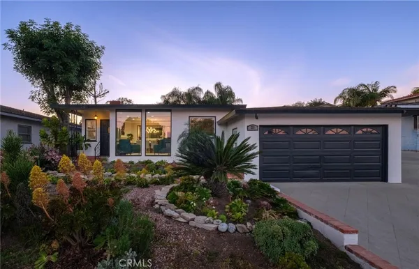 a view of a house with a yard and potted plants