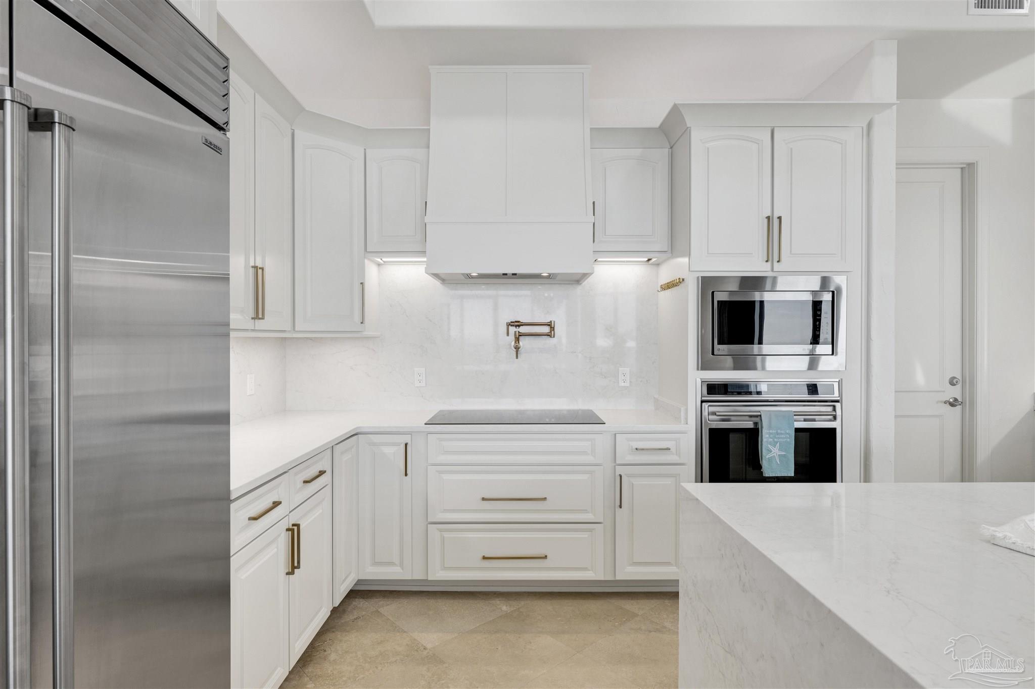 16551 Perdido Key Drive, Unit PH701 Perdido Key, FL 32507 - Photo 15 of 62 a kitchen with white cabinets and stainless steel appliances