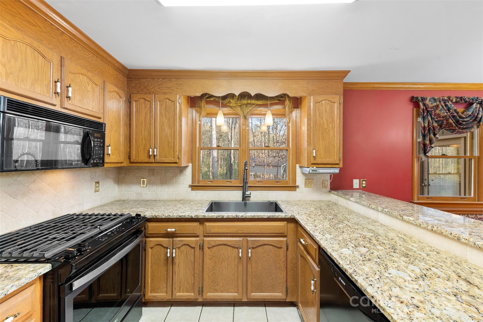3026 Forbes Road Gastonia, NC 28056 - Photo 11 of 42 a kitchen with granite countertop wooden cabinets a sink and a stove