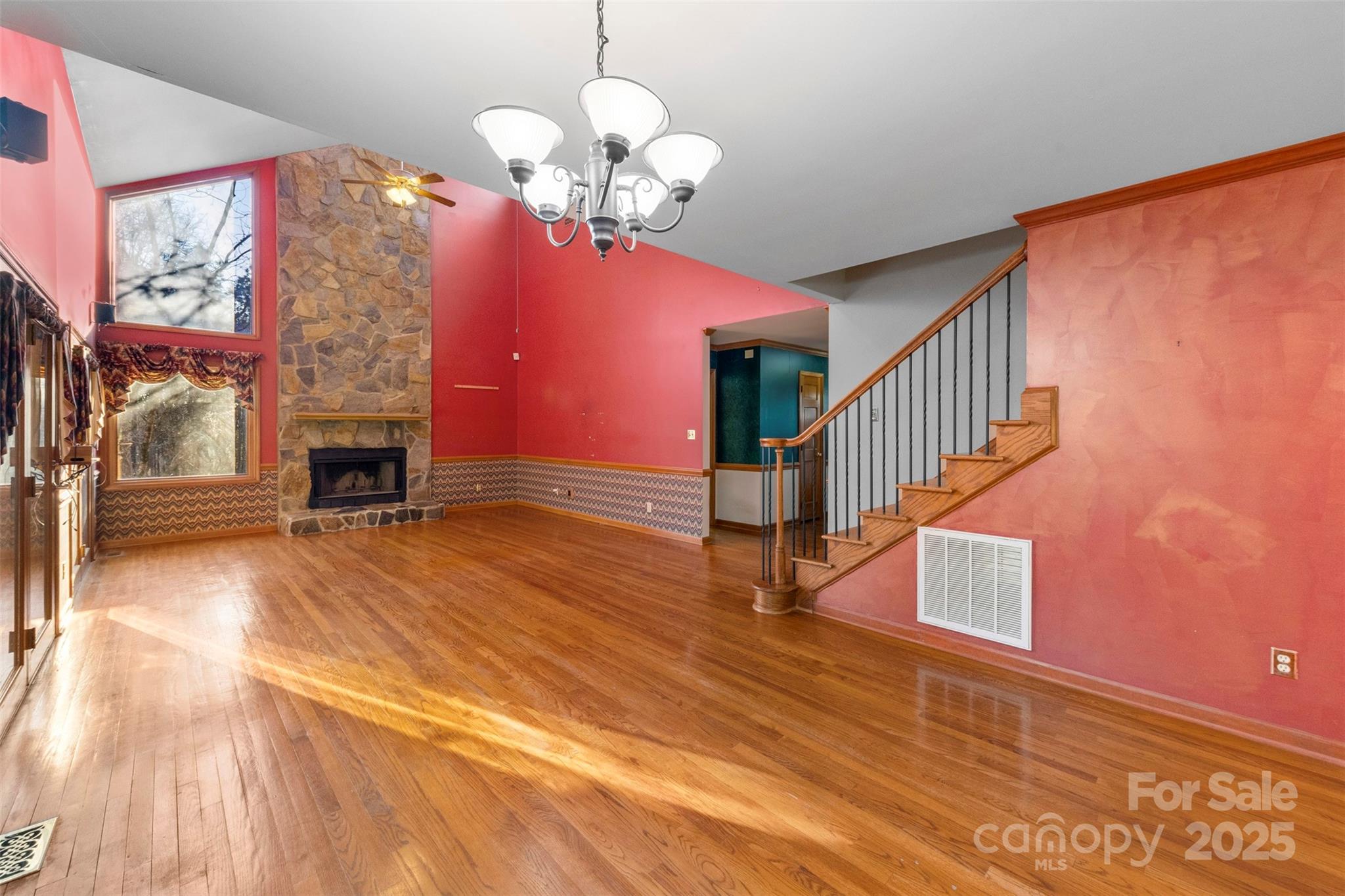 3026 Forbes Road Gastonia, NC 28056 - Photo 5 of 42 a view of a livingroom with wooden floor a fireplace a chandelier and windows