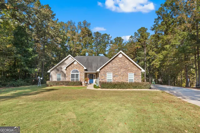 a front view of a house with a yard and trees