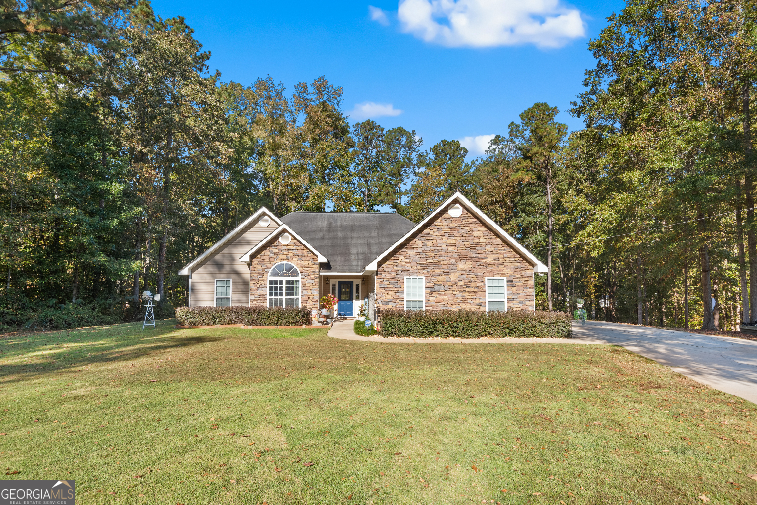 a front view of a house with a yard and trees