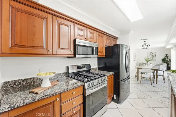 a kitchen with stainless steel appliances granite countertop a refrigerator stove microwave and sink