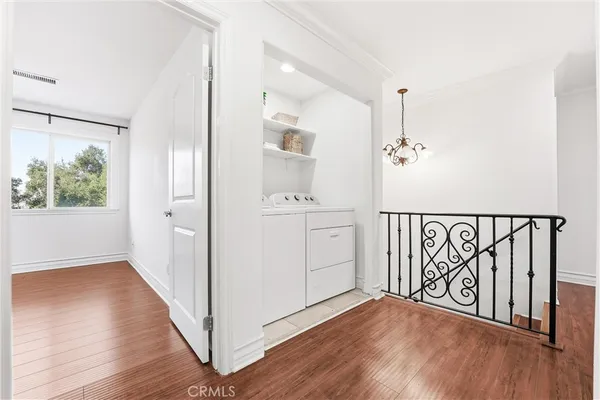a view of a hallway with wooden floor and staircase