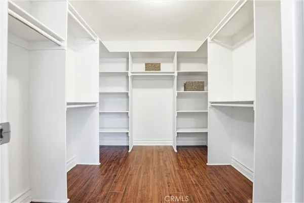 a room with walk in closet and wooden floor