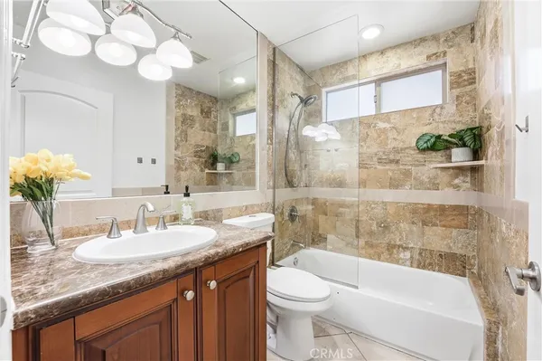 a bathroom with a granite countertop sink a toilet and bathtub