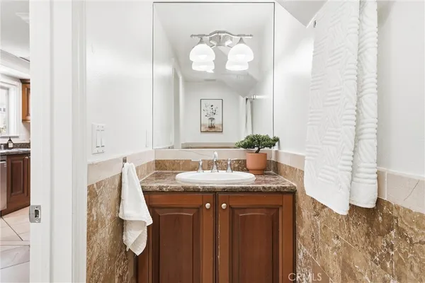 a bathroom with a granite countertop sink a mirror and a shower