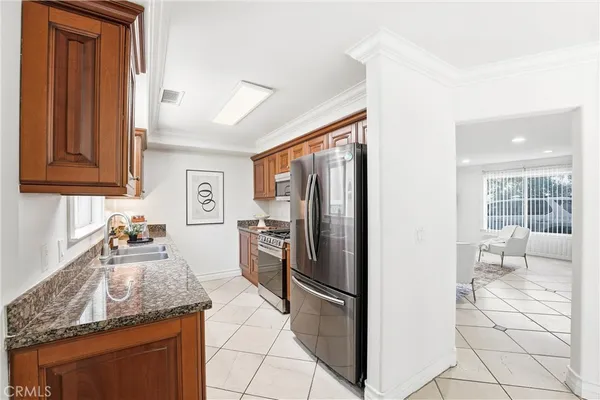 a kitchen with granite countertop a refrigerator and a sink