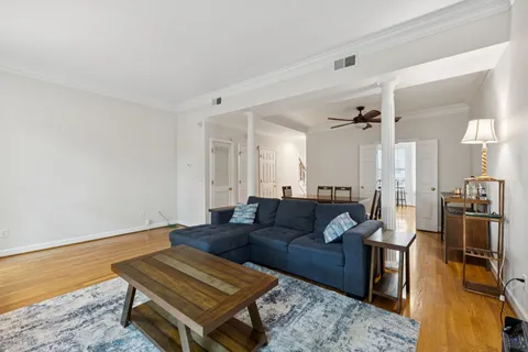 a living room with furniture a wooden floor and next to a window