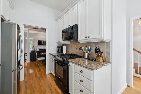 a kitchen with granite countertop a sink stove and refrigerator