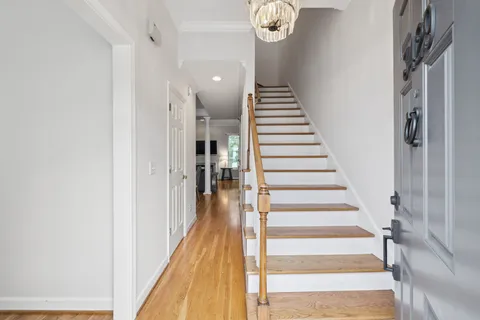 a view of a hallway with wooden floor and entryway