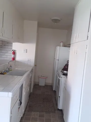 a kitchen with a sink a refrigerator and a stove