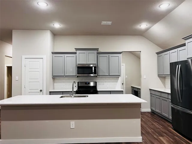 a kitchen with kitchen island a sink stainless steel appliances and cabinets