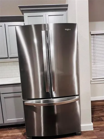 a view of a refrigerator in kitchen with wooden floor
