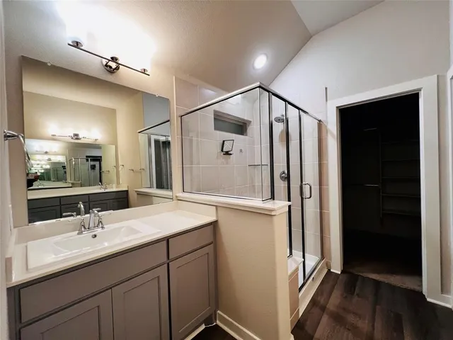 a bathroom with a double vanity sink mirror and shower