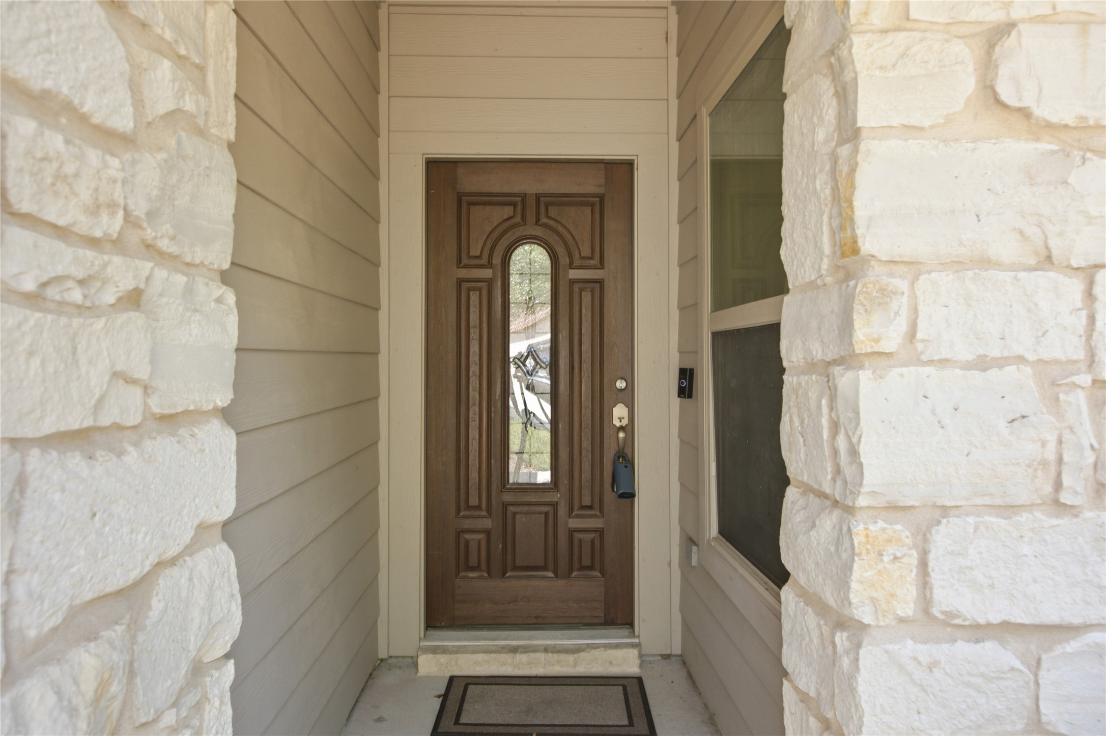 2601 Rough Berry Road Pflugerville, TX 78660 - Photo 6 of 36 A welcoming entry features natural stone accents and horizontal siding, leading to a richly detailed wooden door.