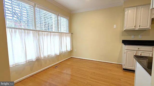 a view of a kitchen with wooden floor and electronic appliances
