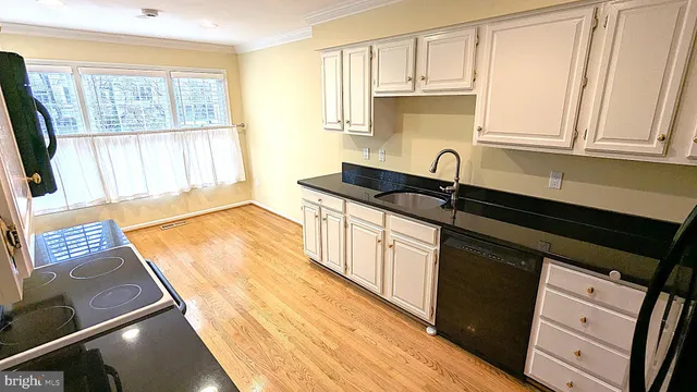 a kitchen with granite countertop a sink stove and cabinets