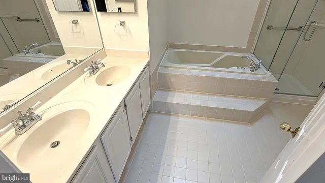 a bathroom with a tub sink and mirror