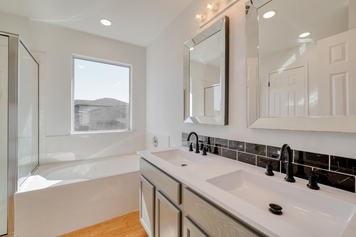 12825 James Madison Street Manor, TX 78653 - Photo 17 of 24 a bathroom with a tub sink and mirror