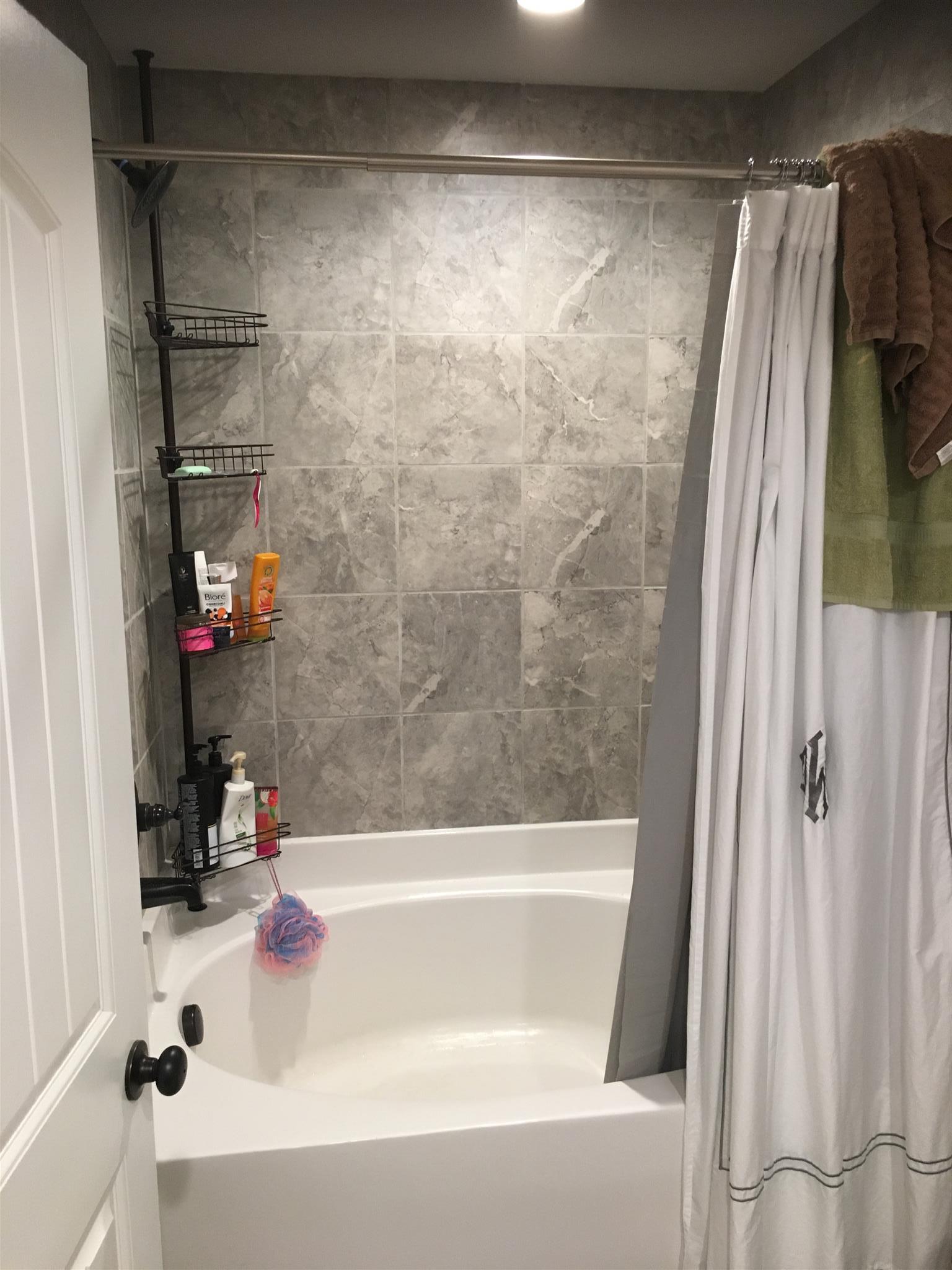 121 Point Road Portland, TN 37148 - Photo 16 of 23 a bathroom with a bathtub and a shower