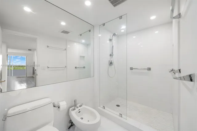 a bathroom with a toilet a sink and shower