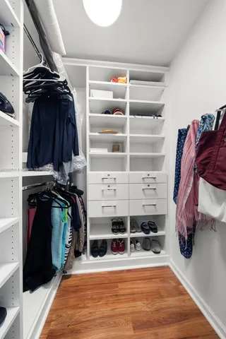 a view of walk in closet with clothes and shoes