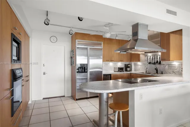 a kitchen with stainless steel appliances granite countertop a sink and a refrigerator