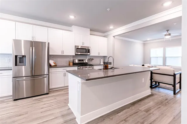 a kitchen with stainless steel appliances a refrigerator sink and microwave